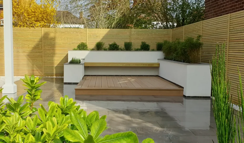 A beautifully landscaped garden with a wooden deck and decorative plants.