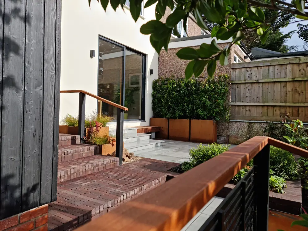Raised terrace courtyard garden in Allerton with brick steps, timber handrails and corten planters