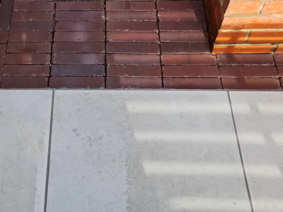 Smooth sandstone paving and clay paver detail in a modern courtyard garden
