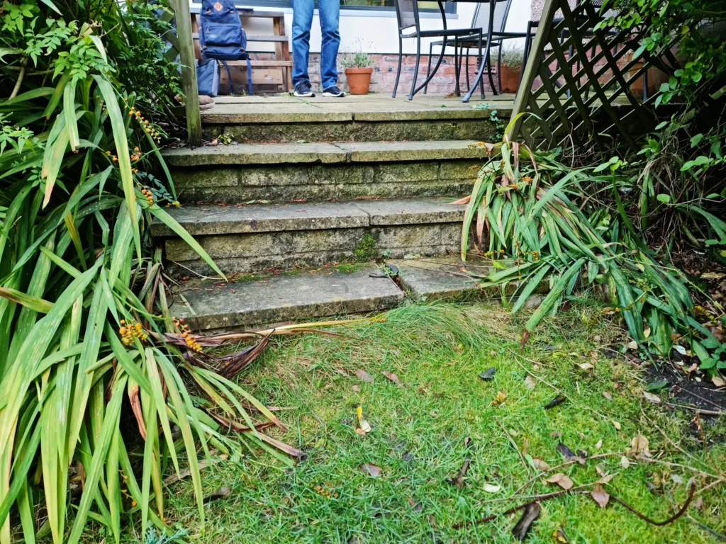 Old uneven garden steps from terrace to lawn before Nordic Soul landscaping work