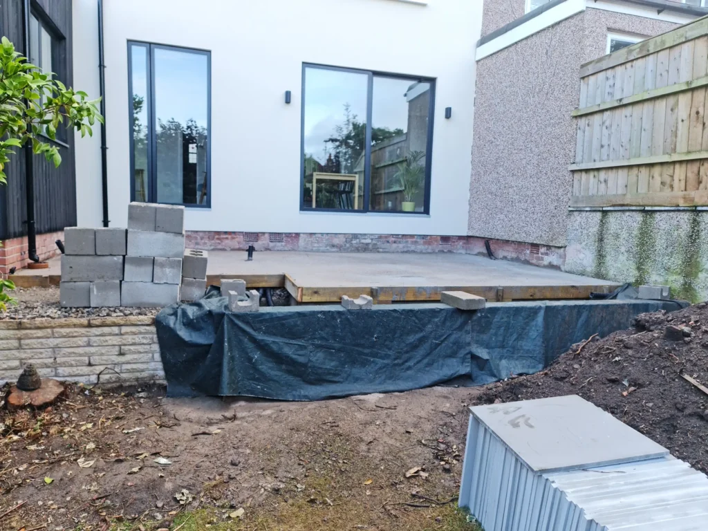 Concrete subbase and rebuilt terrace walls prepared for courtyard garden paving