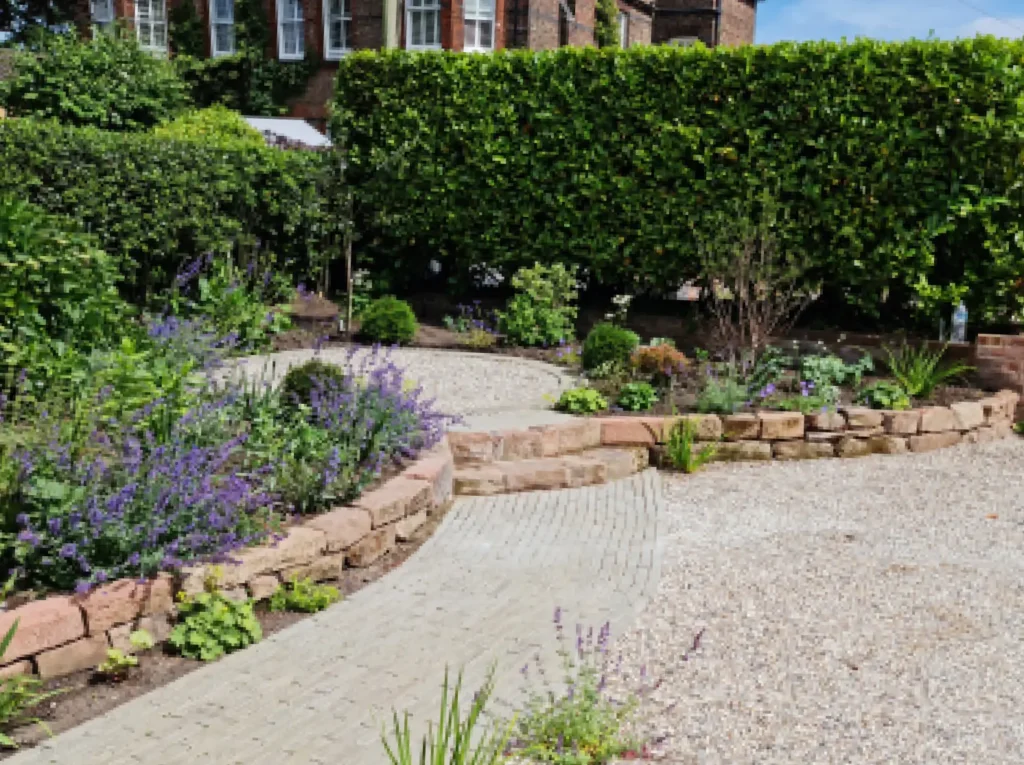 Front garden remodel in Altrincham with gravel driveway, brick walling and soft planting