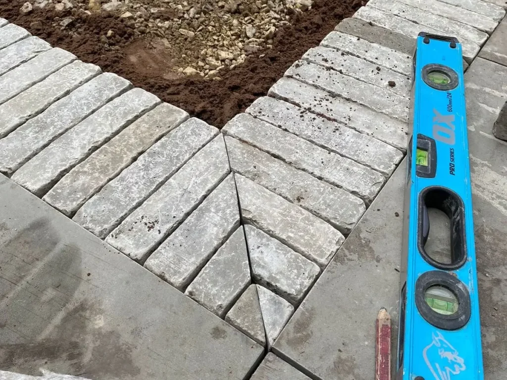 Detailed mitre cuts in clay paver edging during Altrincham garden landscaping