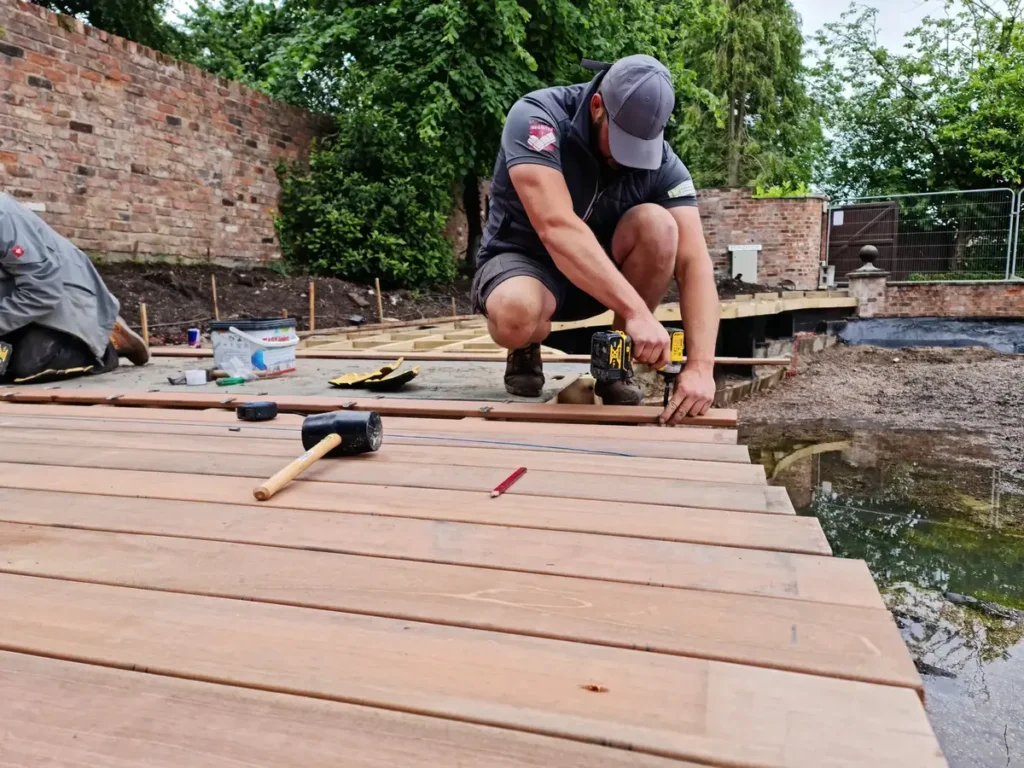 Landigo team installing timber deck boards with hidden fixings around renovated pool