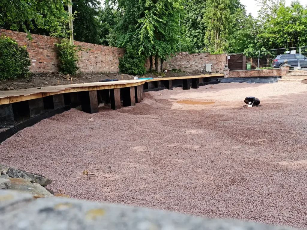 Fresh gravel redressing the cleaned pool base during Wilmslow waterside garden restoration