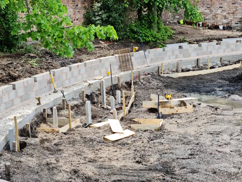 Concrete block retaining wall and foundations built to stabilise eroding pool bank
