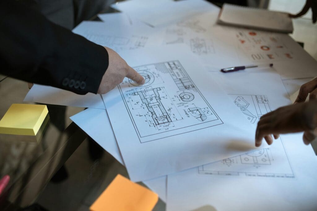 Close-up of hands reviewing architectural plans and drawings.