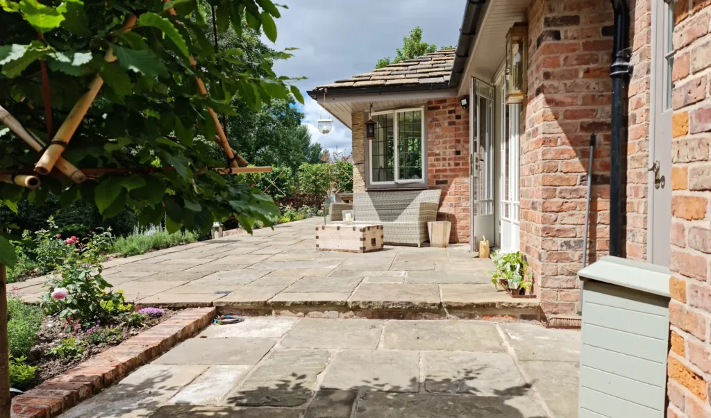 Landscaped garden patio with flowers and stone pathways.